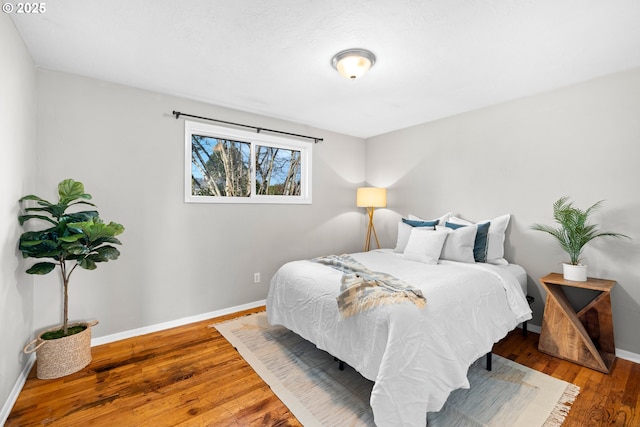 bedroom featuring baseboards and hardwood / wood-style flooring