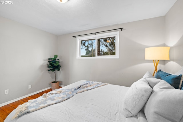 bedroom featuring baseboards and wood finished floors