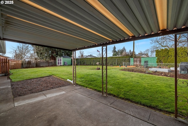 view of patio / terrace featuring an outbuilding, a storage unit, and a fenced backyard