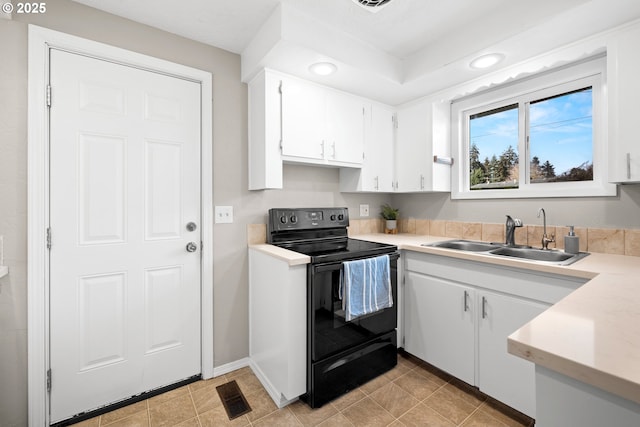 kitchen with visible vents, a sink, black range with electric cooktop, white cabinetry, and light countertops