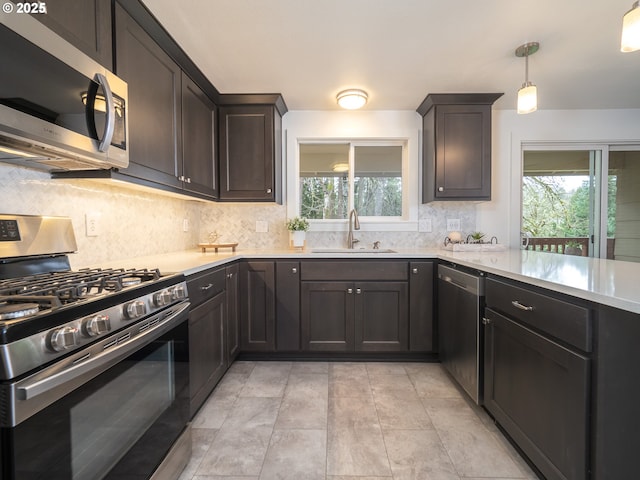 kitchen featuring a wealth of natural light, appliances with stainless steel finishes, light countertops, and a sink