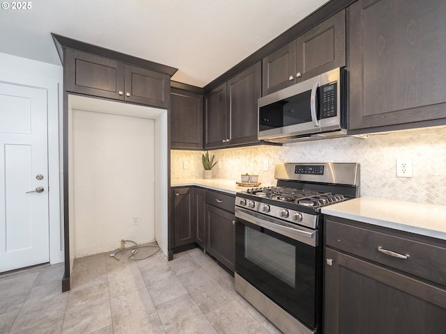 kitchen featuring backsplash, light countertops, dark brown cabinets, and appliances with stainless steel finishes