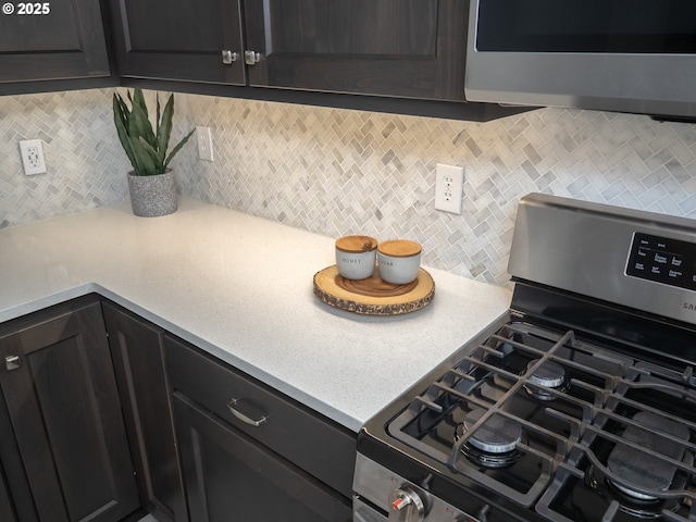 kitchen featuring stainless steel appliances, tasteful backsplash, and light countertops