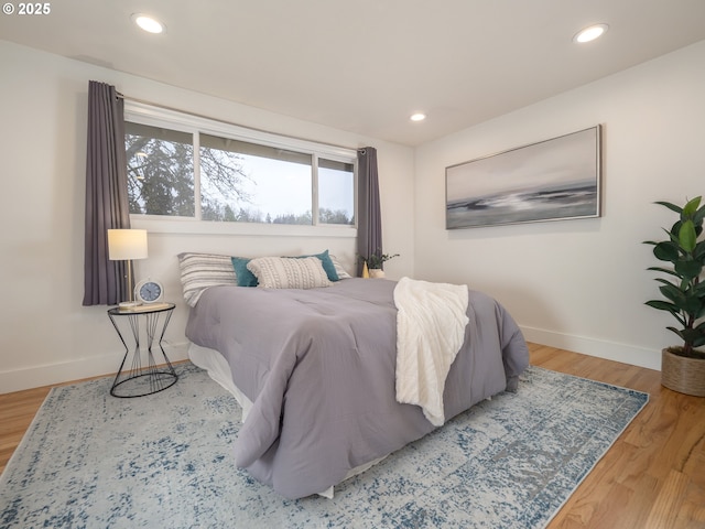 bedroom with recessed lighting, wood finished floors, and baseboards