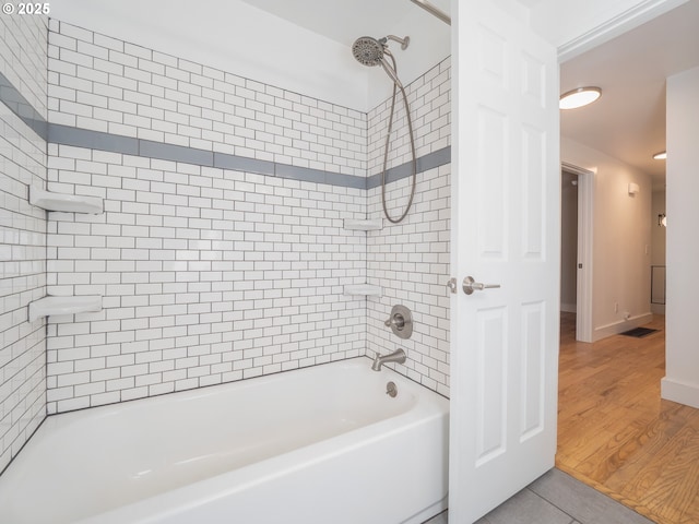 full bathroom with shower / bathing tub combination, wood finished floors, and baseboards