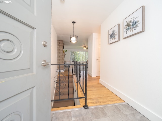 stairs with wood finished floors and baseboards