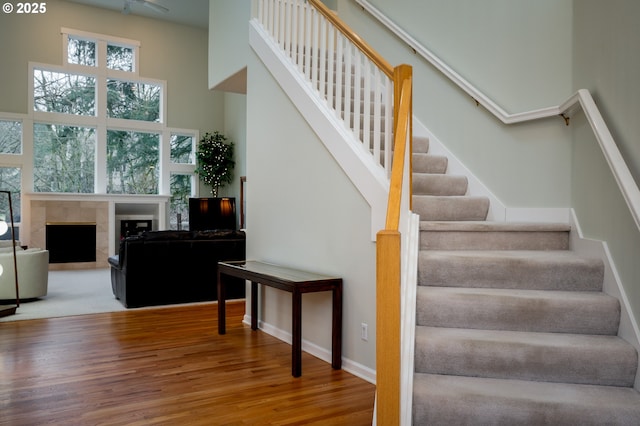 stairs featuring wood-type flooring and a towering ceiling