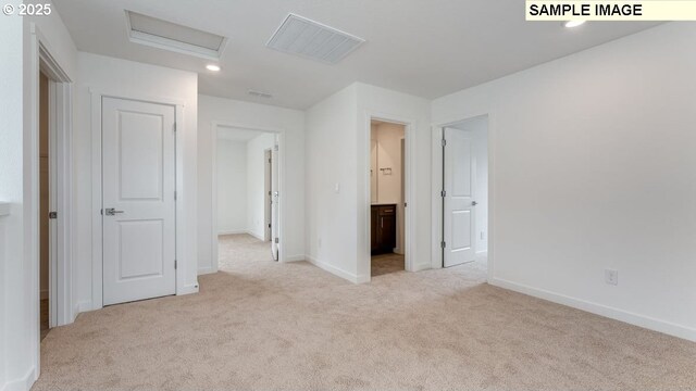 unfurnished bedroom featuring attic access, baseboards, carpet flooring, and ensuite bathroom