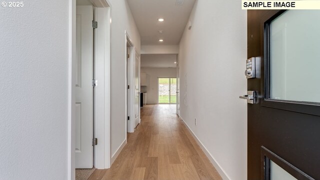 corridor with baseboards, recessed lighting, and light wood-style floors