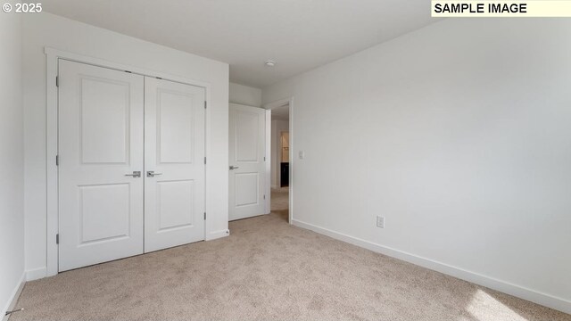 unfurnished bedroom featuring carpet, baseboards, and a closet