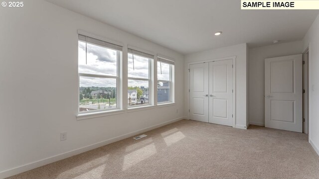 unfurnished bedroom featuring visible vents, baseboards, light colored carpet, a closet, and recessed lighting