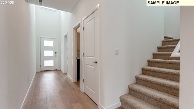 interior space with stairway, light wood-type flooring, and baseboards