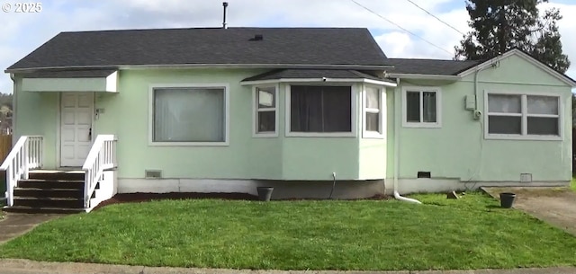 back of property with crawl space, a shingled roof, and a lawn