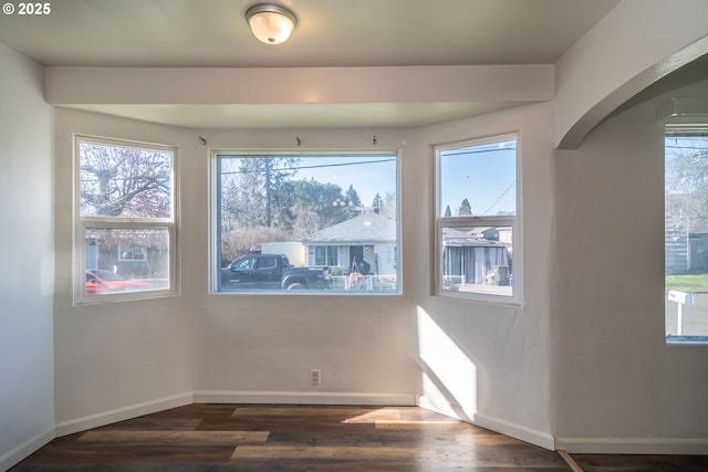 interior space with dark wood-style flooring and baseboards