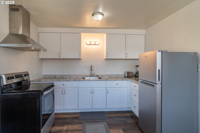 kitchen with stainless steel appliances, white cabinets, a sink, wall chimney range hood, and light stone countertops