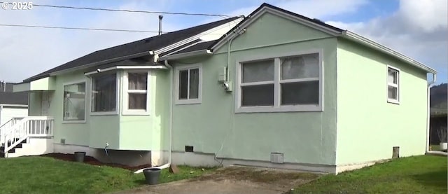 view of side of home with a yard and stucco siding