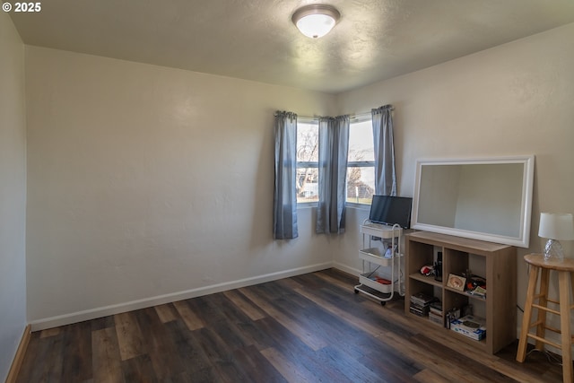 interior space featuring baseboards and dark wood finished floors