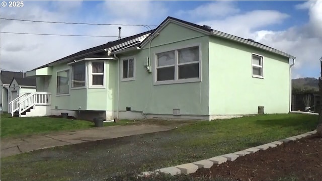 view of property exterior featuring a lawn and stucco siding