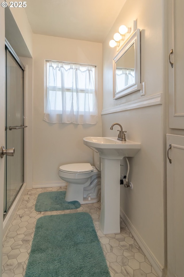 full bathroom with tile patterned floors, toilet, baseboards, and an enclosed shower