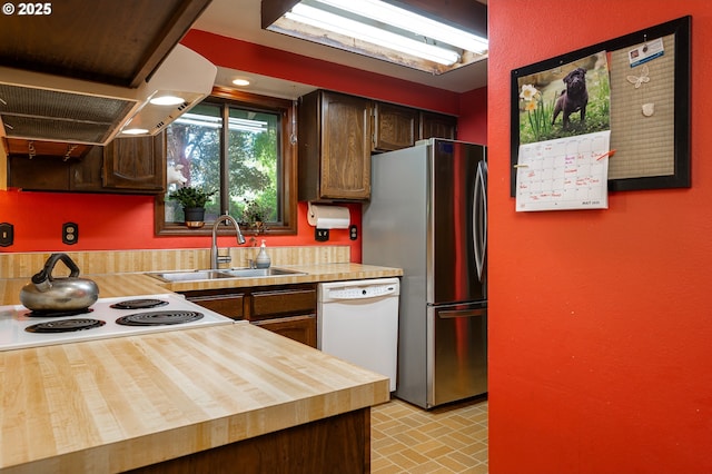1363 SE 135th Ave, Portland, OR 97233 - kitchen featuring dishwasher, wooden counters, a sink, freestanding refrigerator, and brick patterned floors