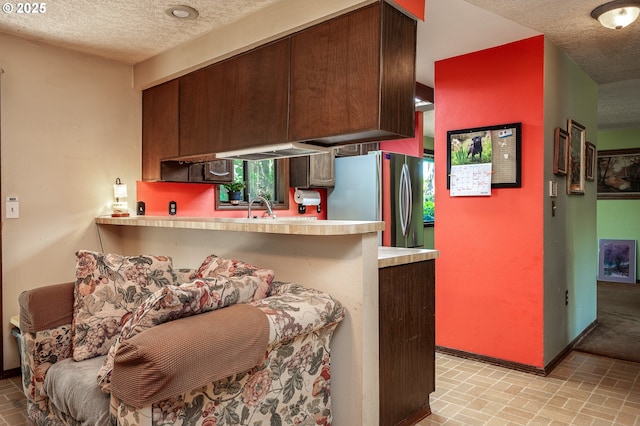 1363 SE 135th Ave, Portland, OR 97233 - kitchen with freestanding refrigerator, brick flooring, baseboards, light countertops, and a textured ceiling