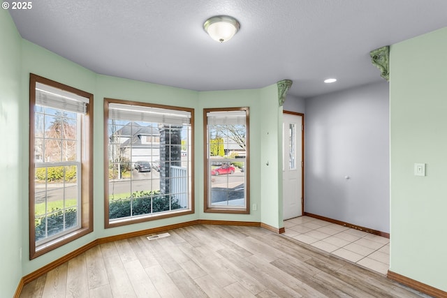 interior space featuring light wood finished floors, plenty of natural light, and baseboards