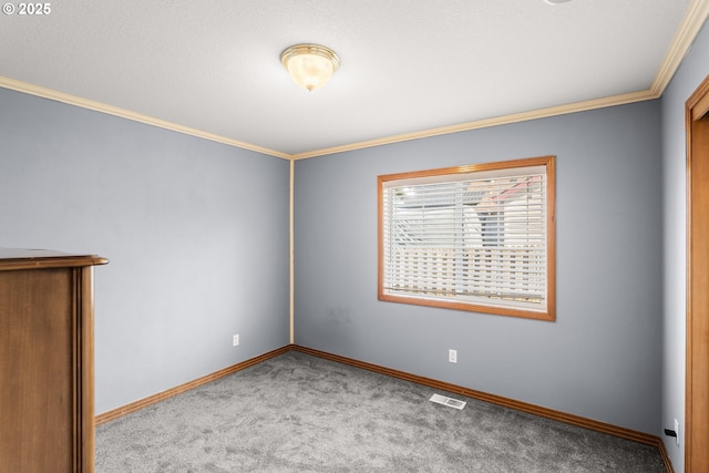 spare room with visible vents, baseboards, crown molding, and carpet flooring