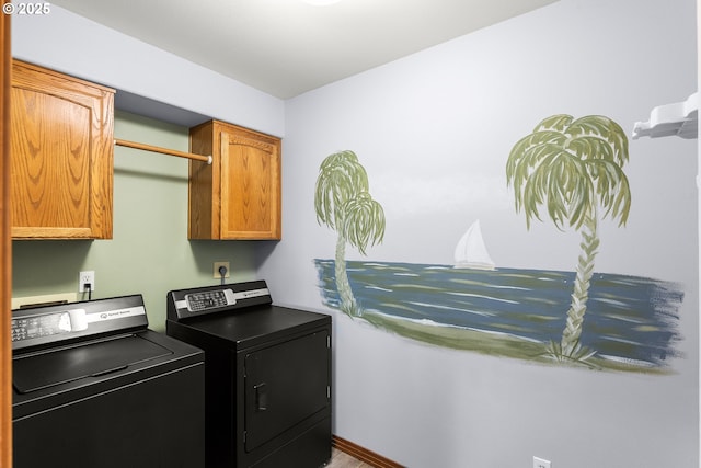 washroom with cabinet space and washing machine and clothes dryer