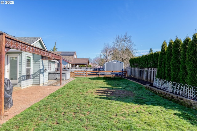 view of yard with a storage shed, a fenced backyard, a patio, and an outdoor structure