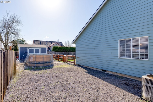 view of yard with an outbuilding, cooling unit, a fenced backyard, a fenced in pool, and a storage unit