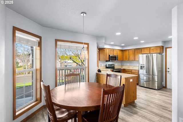 dining space with light wood-type flooring and recessed lighting