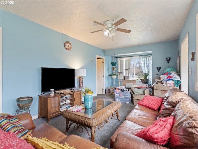 living room featuring baseboards, carpet, a ceiling fan, and a textured ceiling