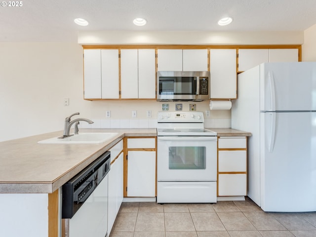 651 SW Westview Dr, Mcminnville, OR 97128 - kitchen featuring white appliances, light countertops, white cabinetry, light tile patterned flooring, and a peninsula