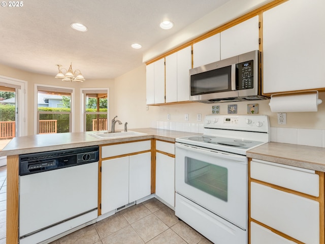 651 SW Westview Dr, Mcminnville, OR 97128 - kitchen featuring white appliances, a peninsula, plenty of natural light, light tile patterned floors, and recessed lighting