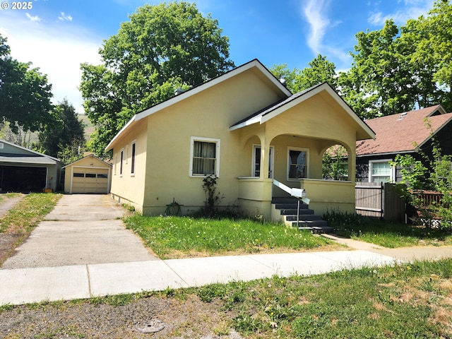 1914 1st St, La Grande, OR 97850 - bungalow-style home with concrete driveway, an outbuilding, a detached garage, stucco siding, and fence