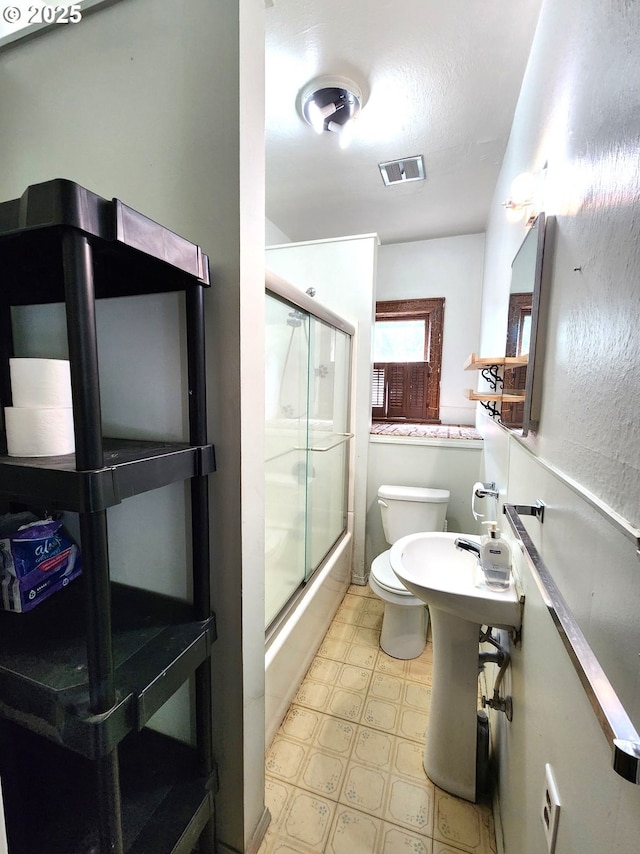 1914 1st St, La Grande, OR 97850 - full bath with tile patterned floors, a shower with door, and toilet