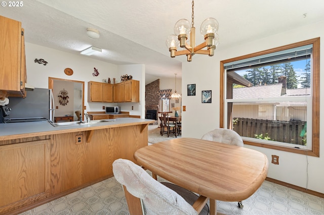 1430 NW 19th St, Gresham, OR 97030 - kitchen with a chandelier, appliances with stainless steel finishes, a peninsula, light flooring, and vaulted ceiling