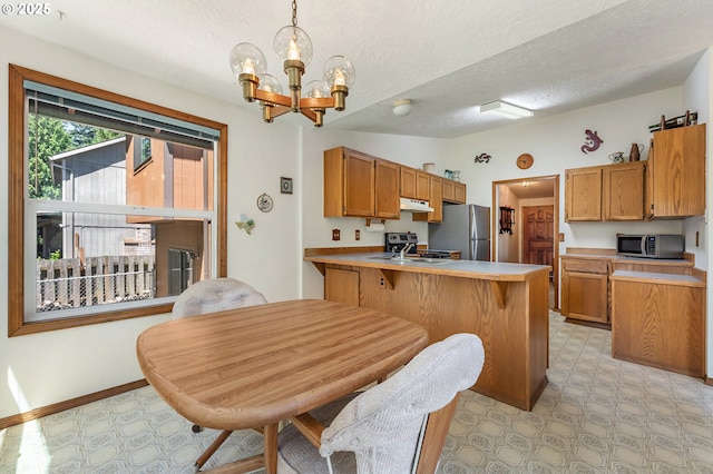 1430 NW 19th St, Gresham, OR 97030 - kitchen with appliances with stainless steel finishes, under cabinet range hood, light flooring, a chandelier, and a peninsula