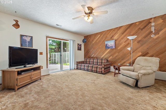 1430 NW 19th St, Gresham, OR 97030 - living room featuring wood walls, ceiling fan, light colored carpet, an accent wall, and a textured ceiling