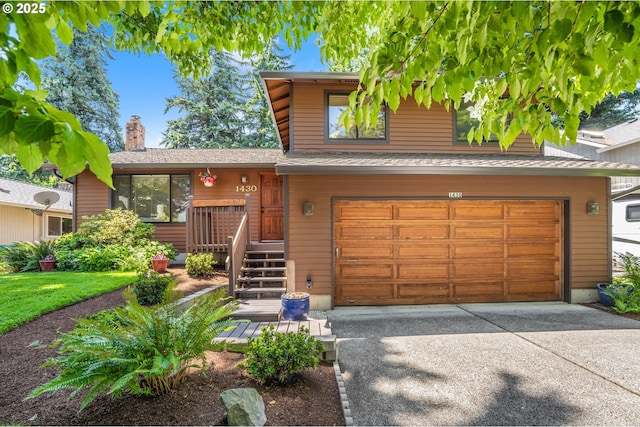 1430 NW 19th St, Gresham, OR 97030 - tri-level home featuring an attached garage, concrete driveway, and a chimney