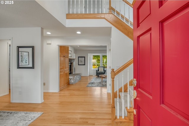 foyer entrance with light hardwood / wood-style flooring and a high ceiling