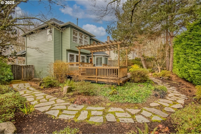 back of house featuring a wooden deck and a pergola