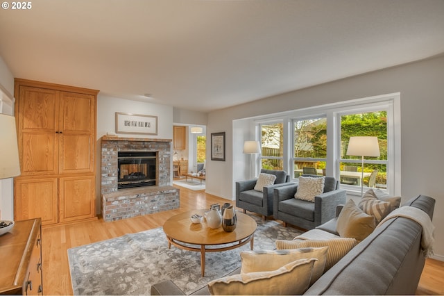 living room featuring a brick fireplace and light wood-type flooring