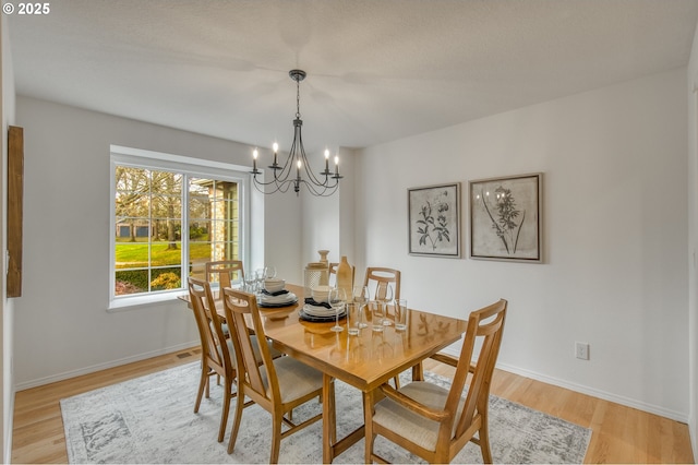 dining area featuring a chandelier and light hardwood / wood-style floors