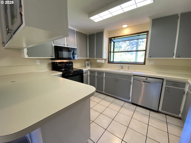 kitchen with black appliances, gray cabinetry, light countertops, light tile patterned floors, and a sink