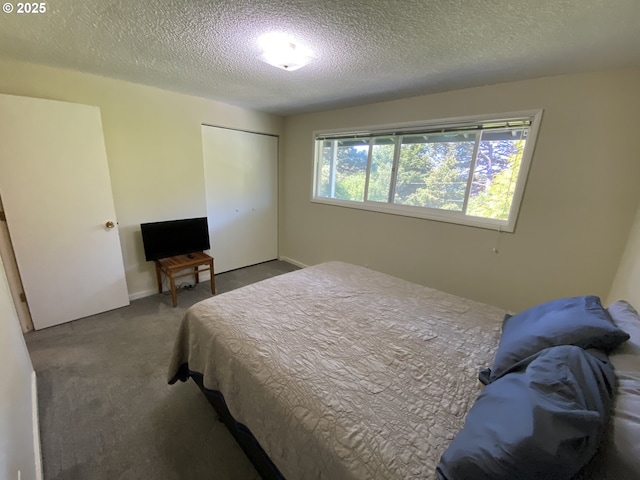 carpeted bedroom featuring a textured ceiling and a closet