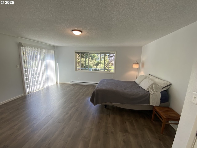 bedroom featuring a baseboard radiator, dark wood-style floors, and a textured ceiling