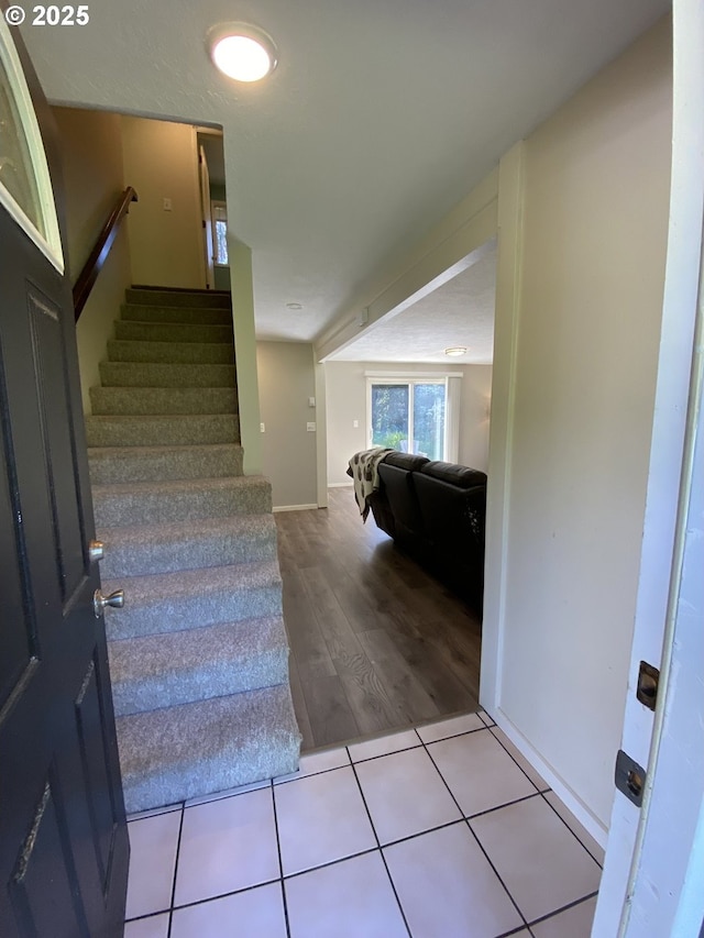 staircase featuring wood finished floors and baseboards