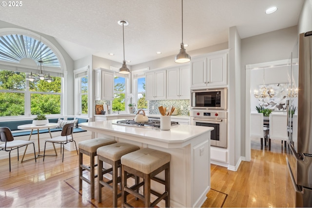 1365 NW 96th Ave, Portland, OR 97229 - kitchen with stainless steel appliances, a chandelier, light countertops, backsplash, and white cabinets