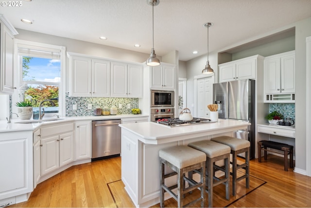 1365 NW 96th Ave, Portland, OR 97229 - kitchen with stainless steel appliances, a sink, decorative backsplash, white cabinetry, and recessed lighting